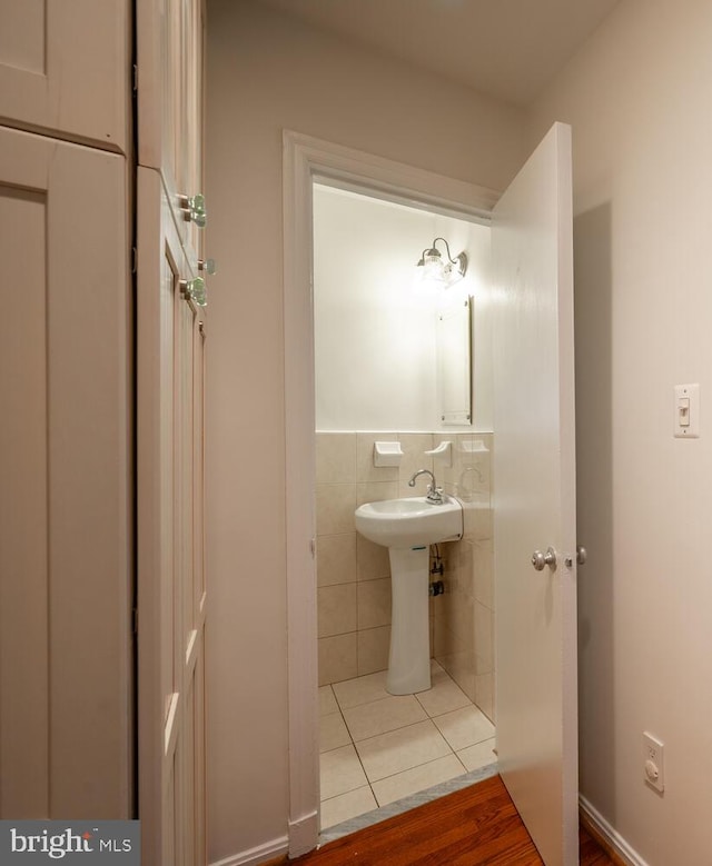 bathroom featuring tile walls, hardwood / wood-style flooring, and sink