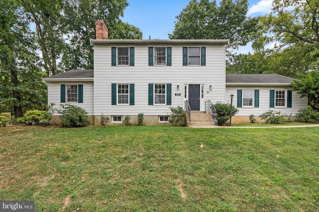 colonial house featuring a front lawn