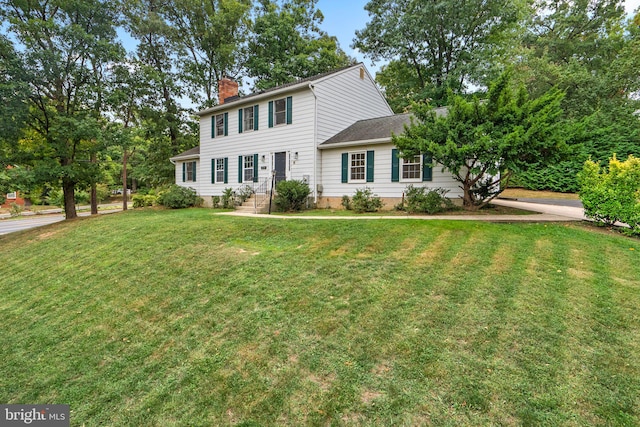 colonial-style house featuring a front lawn