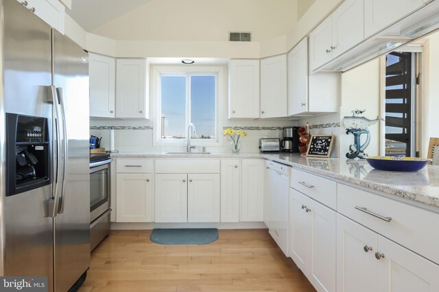 kitchen featuring stainless steel appliances, white cabinetry, and sink