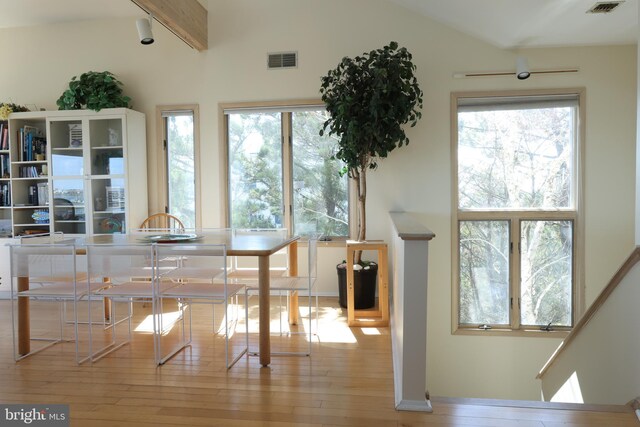 interior space featuring light hardwood / wood-style floors, lofted ceiling with beams, and a healthy amount of sunlight