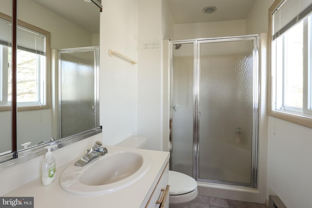 bathroom with toilet, a shower with door, and vanity