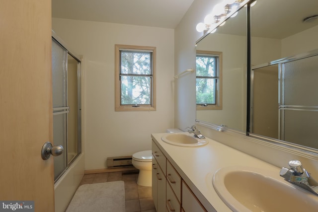 full bathroom featuring vanity, toilet, tile patterned floors, a baseboard heating unit, and enclosed tub / shower combo