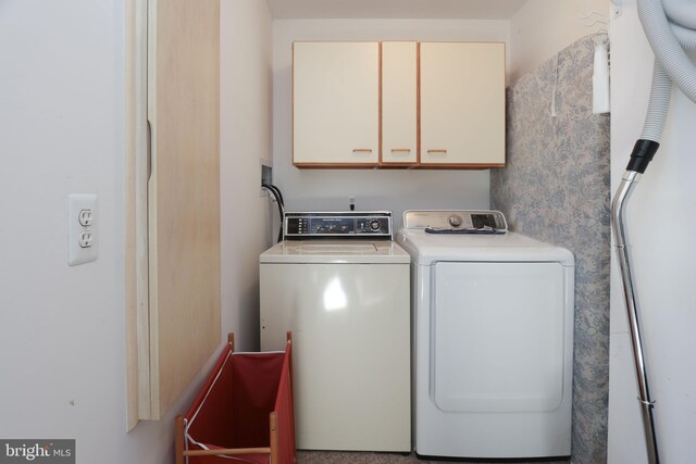 clothes washing area featuring cabinets and washer and dryer