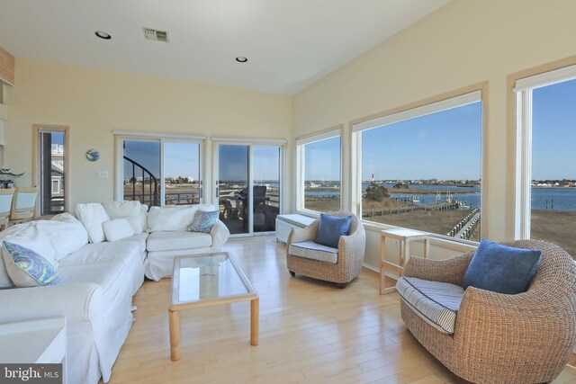 living room with a water view and light hardwood / wood-style floors