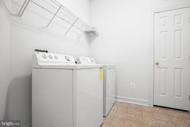 laundry room with light tile patterned floors and washing machine and clothes dryer