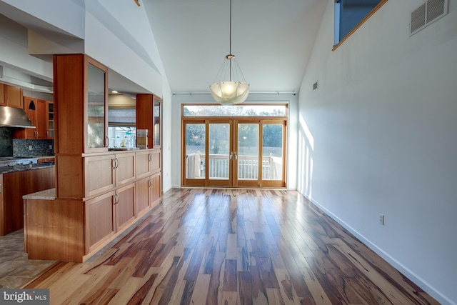 interior space featuring french doors, high vaulted ceiling, and wood-type flooring