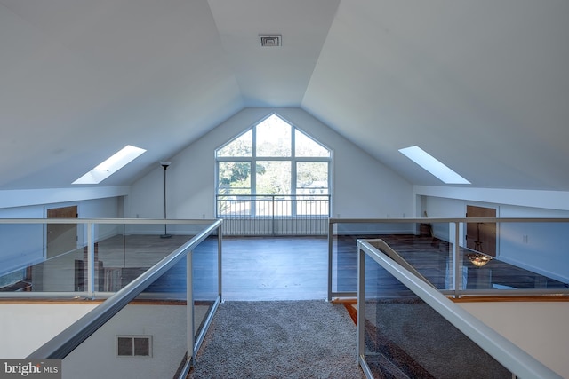 bonus room featuring vaulted ceiling with skylight and dark hardwood / wood-style flooring