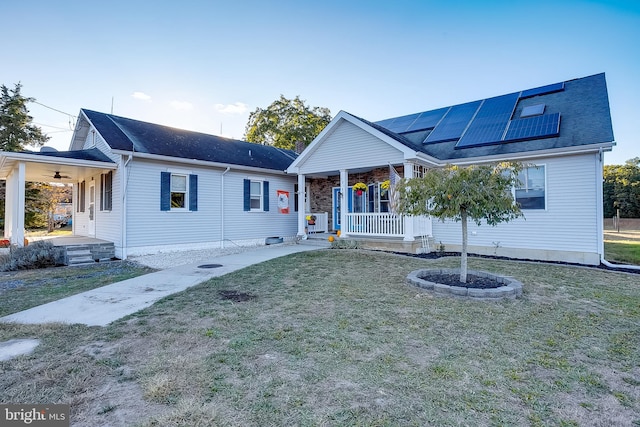 view of front of home featuring covered porch, a front yard, and solar panels