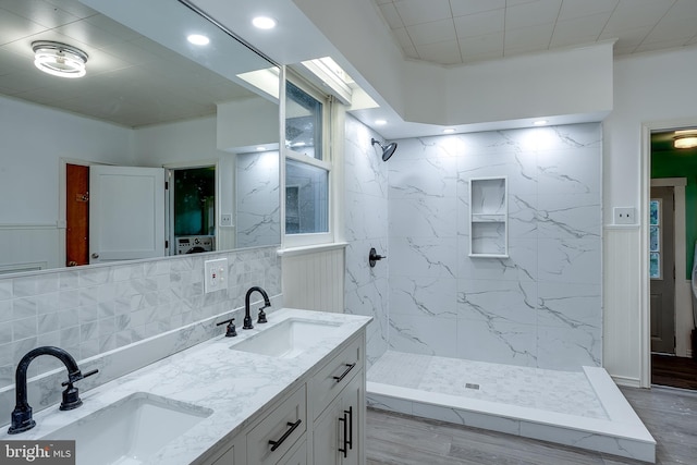 bathroom with vanity, backsplash, hardwood / wood-style flooring, and tiled shower