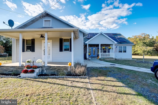 bungalow featuring covered porch, a front lawn, and ceiling fan