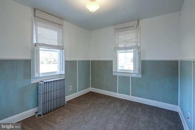 unfurnished room featuring radiator heating unit and carpet floors