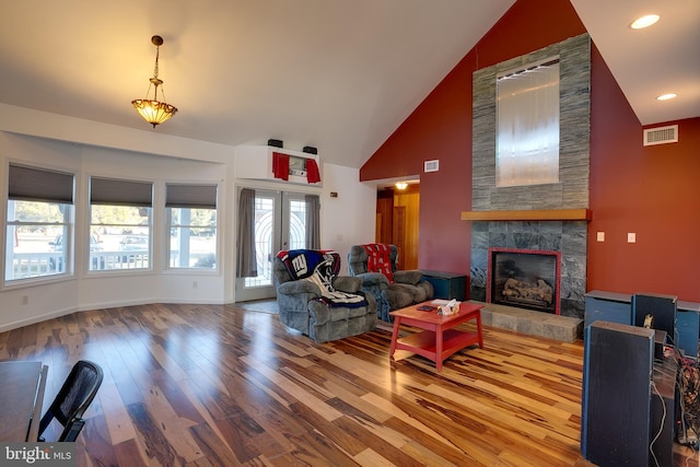 living room featuring high vaulted ceiling, french doors, hardwood / wood-style flooring, and a tile fireplace