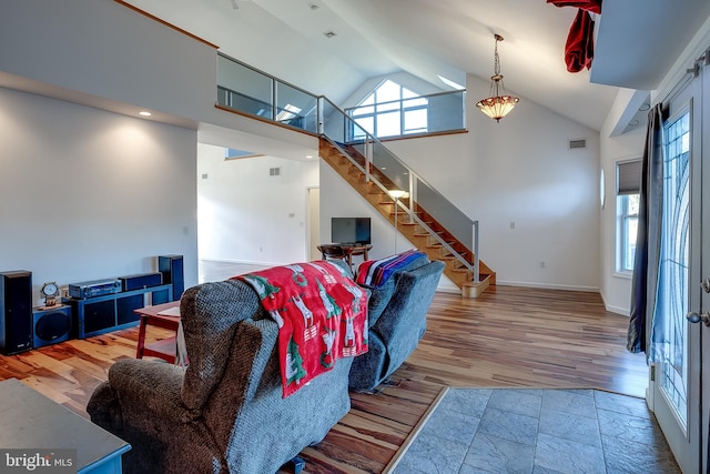 living room with hardwood / wood-style floors and high vaulted ceiling