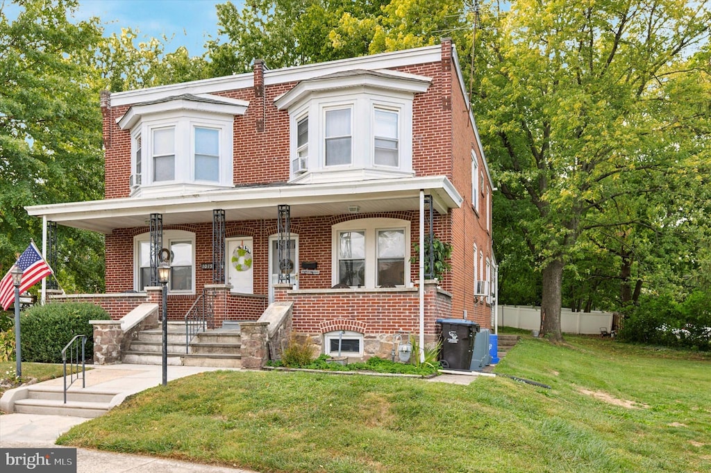 view of front of house with a front yard and a porch