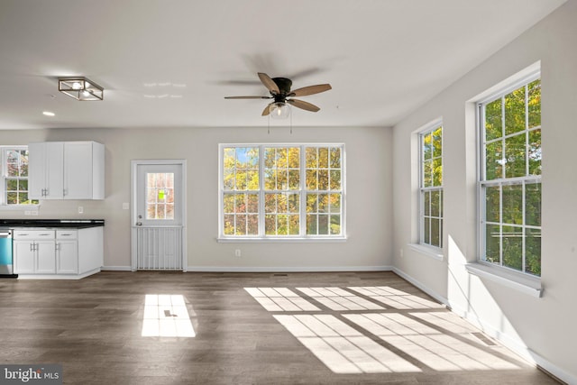 interior space with ceiling fan, a healthy amount of sunlight, and dark hardwood / wood-style flooring