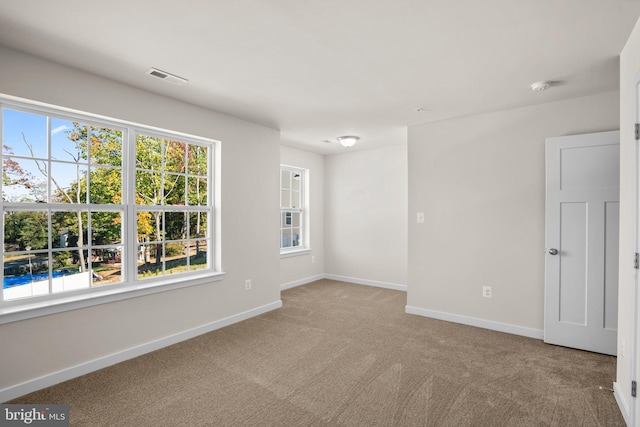 unfurnished room featuring light colored carpet