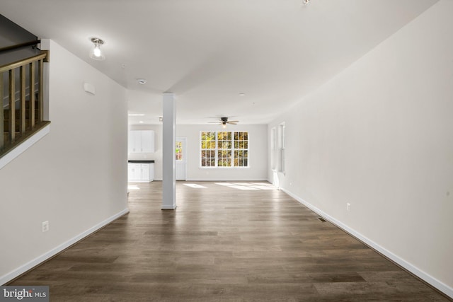 unfurnished living room with dark wood-type flooring and ceiling fan