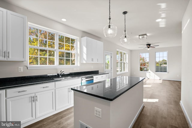 kitchen with a center island, sink, dark hardwood / wood-style floors, and white cabinets