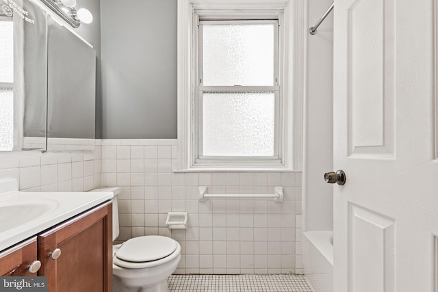 bathroom with vanity, tile walls, tile patterned flooring, and toilet