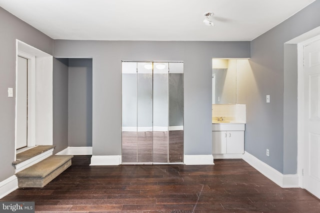 interior space with sink, a closet, connected bathroom, and dark hardwood / wood-style flooring