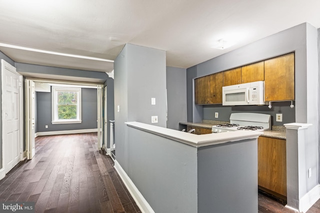 kitchen with baseboards, white appliances, dark wood-type flooring, and brown cabinets