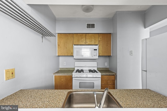 kitchen featuring white appliances and sink