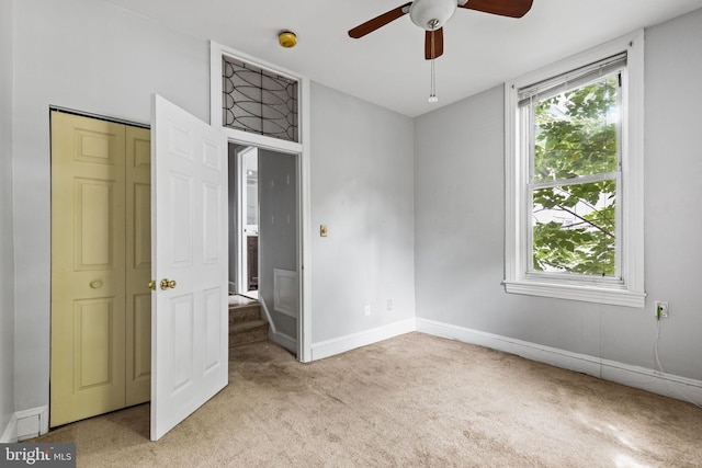 unfurnished bedroom featuring ceiling fan, a closet, and light carpet