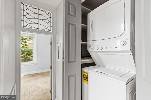 clothes washing area with light carpet and stacked washer / dryer