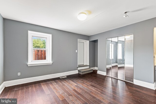 unfurnished room with dark wood-type flooring