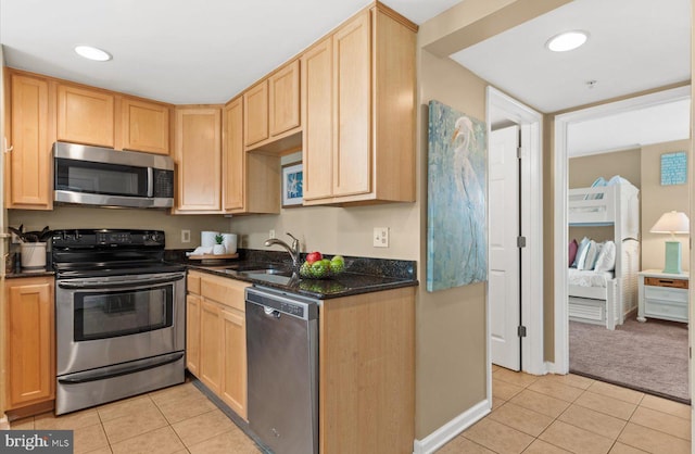 kitchen with light brown cabinetry, sink, light tile patterned floors, and stainless steel appliances