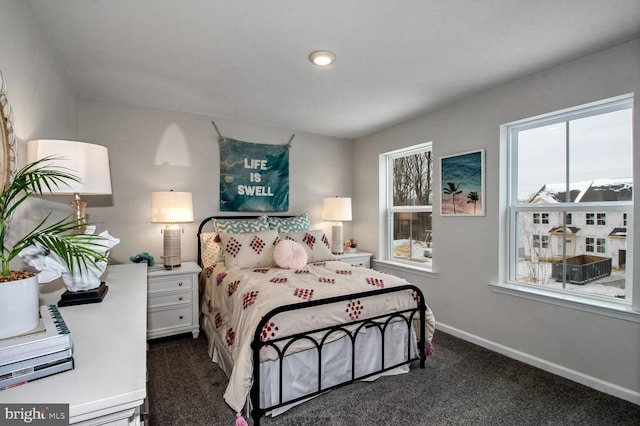bedroom featuring dark colored carpet and baseboards