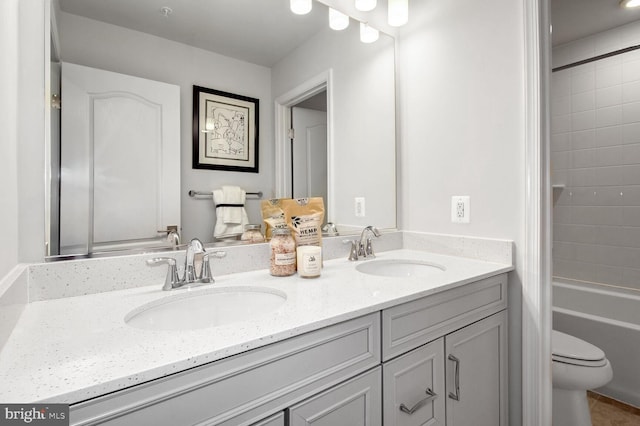 full bathroom with double vanity, toilet,  shower combination, and a sink