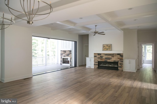 unfurnished living room featuring ceiling fan, beamed ceiling, a fireplace, and dark hardwood / wood-style flooring