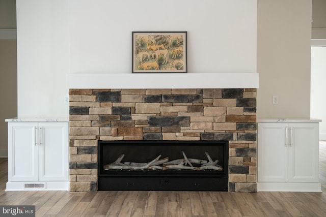 details with a stone fireplace and hardwood / wood-style flooring