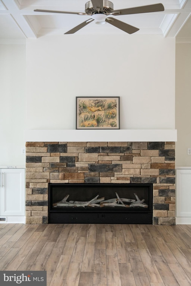 room details featuring ceiling fan, ornamental molding, coffered ceiling, hardwood / wood-style flooring, and a fireplace