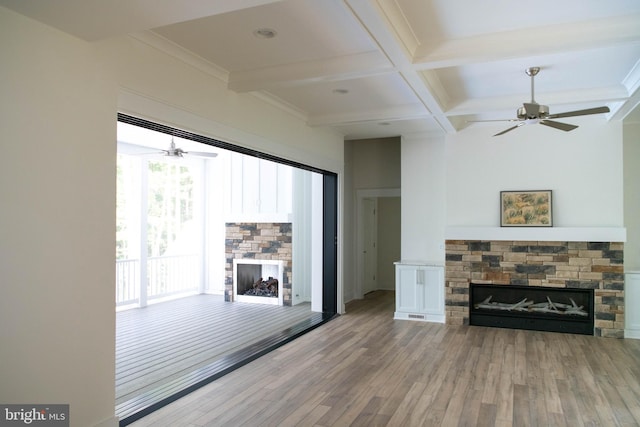 living room with coffered ceiling, a fireplace, beamed ceiling, ceiling fan, and hardwood / wood-style flooring