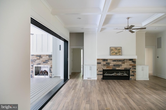 living room with ceiling fan, beamed ceiling, hardwood / wood-style flooring, and a fireplace