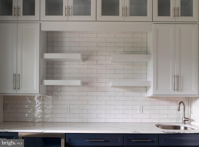 kitchen with blue cabinets, sink, and white cabinets