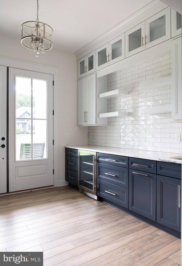 kitchen with wine cooler, light hardwood / wood-style floors, white cabinetry, backsplash, and blue cabinetry