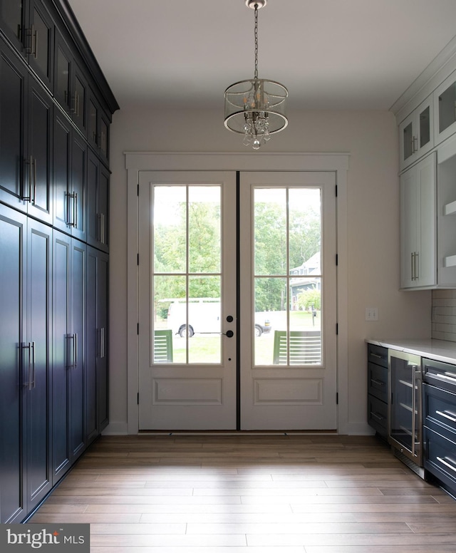 doorway featuring light hardwood / wood-style flooring, a chandelier, and wine cooler