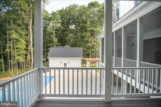 deck with a sunroom and an outbuilding