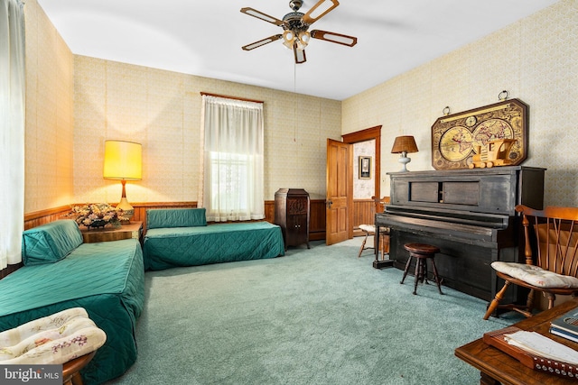 carpeted living room featuring a ceiling fan and wallpapered walls
