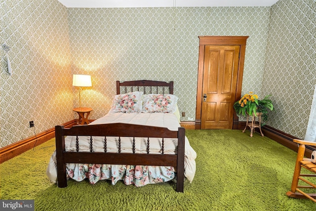 carpeted bedroom featuring wallpapered walls and baseboards