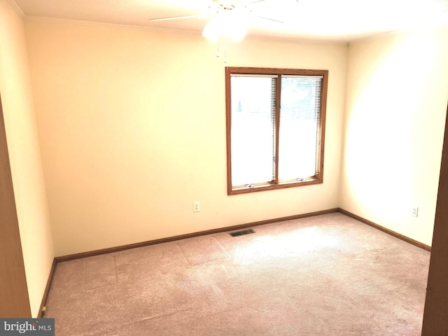 unfurnished room with ornamental molding, ceiling fan, and light colored carpet