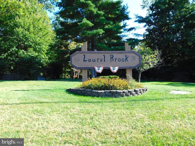 community / neighborhood sign featuring a lawn