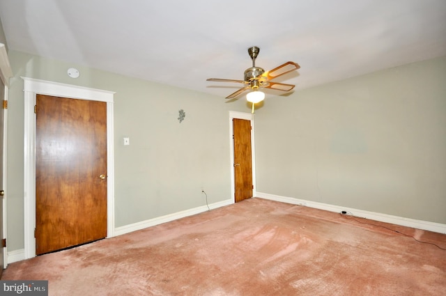 carpeted spare room featuring a ceiling fan and baseboards