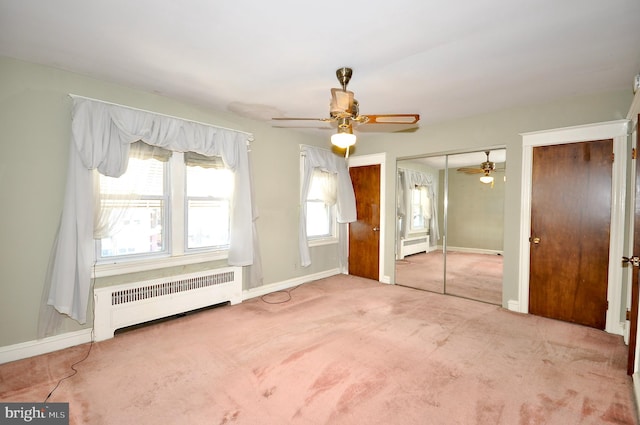 unfurnished bedroom featuring ceiling fan, carpet floors, radiator heating unit, and baseboards