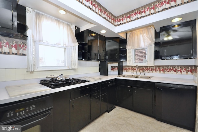 kitchen featuring dark cabinets, light countertops, a sink, and black appliances