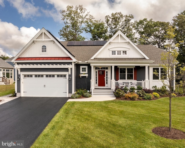 craftsman house with covered porch, a front yard, and a garage